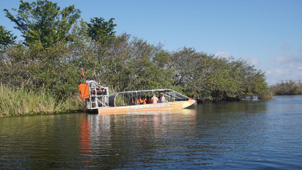 An airboat tour cruising through the Everglades with passengers enjoying the scenic wetlands