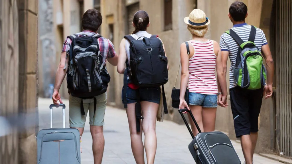 Group of Tourists Walking with Luggage and Backpacks